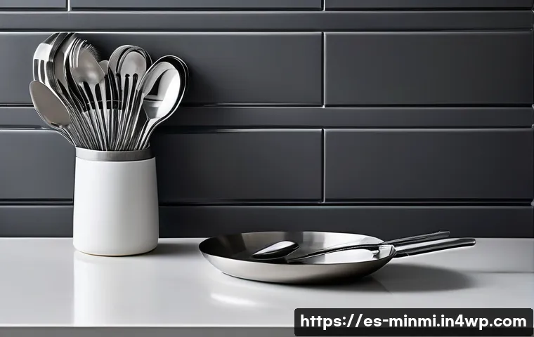 미니멀 럭셔리 주방용품 리스트 - A sleek, modern minimalist kitchen scene showcasing premium stainless steel utensils with polished, ...